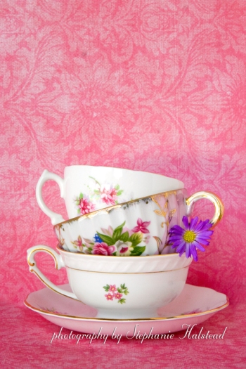 "A Touch of Elegance".  Teacups on rose background.